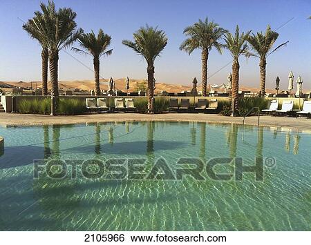 Stock Photograph - United Arab Emirates, Abu Dahbi, Qasr al Sarab, Qasr al Sarab hotel, Main pool and dunes. Fotosearch