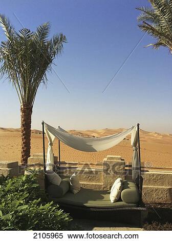 Stock Photography - United Arab Emirates, Abu Dahbi, Qasr al Sarab, Poolside seating and dunes. Fotosearch