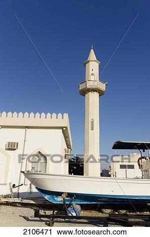 Stock Image - United Arab Emirates, Boat in front of mosque; Ras Al Khaimah. Fotosearch