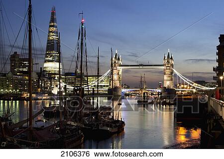 Stock Photograph - United Kingdom, City skyline with Tower Bridge and Shard building at dusk; London. Fotosearch