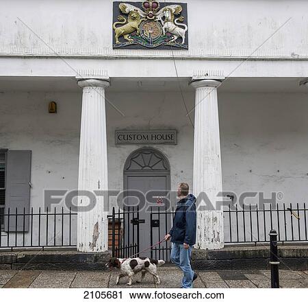 Stock Image - United Kingdom, England, Cornwall, Man walking dog in front of Custom House; Falmouth. Fotosearch
