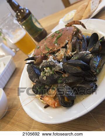 United Kingdom, England, Cornwall, mussels and tiger prawns platter in white wine and cream sauce with salad and bread; Falmouth, Whole crab, Fresh Cornish seafood View Large Photo Image Stock Image - United Kingdom, England, Cornwall, mussels and tiger prawns platter in white wine and cream sauce with salad and bread; Falmouth, Whole crab, Fresh Cornish seafood. Fotosearch