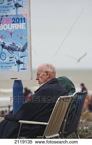 Stock Photography - United Kingdom, England, Elderly spectators sitting on seafront at Eastbourne airshow; East Sussex. Fotosearch