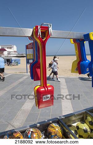 Stock Image - United Kingdom, England, Norfolk, Spades And Plastic Footballs On Stall Display; Great Yarmouth. Fotosearch