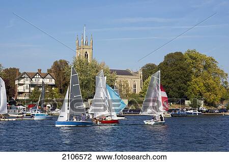 Stock Image - United Kingdom, England, Sailing on River Thames and Hampton church in background; Middlesex. Fotosearch