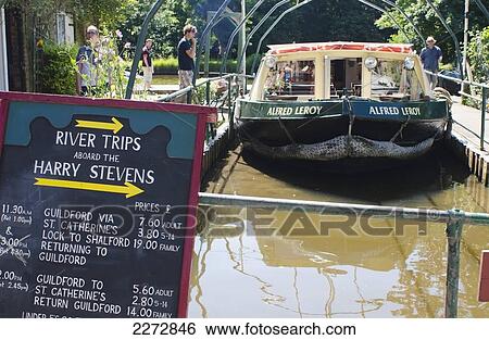 Stock Photograph - United Kingdom, England, Surrey, Tourist boat docked at Guildford canal; Guilford. Fotosearch