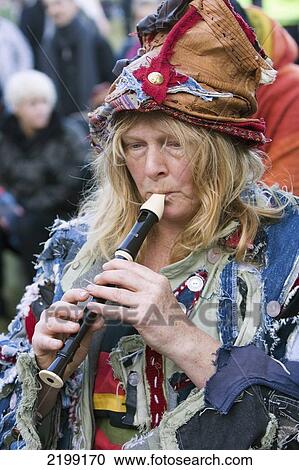 Stock Image - United Kingdom, England, Woman Playing Flute At Stonehenge Festival; Wiltshire. Fotosearch