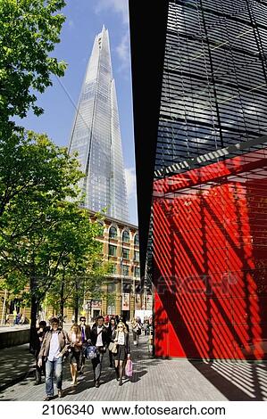 Stock Image - United Kingdom, More London; London, Shard building in background, People passing modern building. Fotosearch