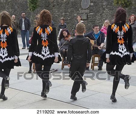 Stock Image - United Kingdom, Northern Ireland, County Londonderry, Irish dancers and musicians playing at Guildhall Square; Derry. Fotosearch