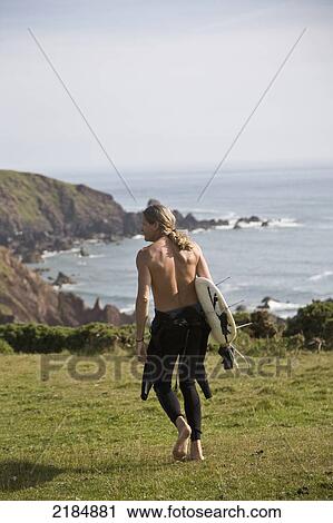 Stock Image - United Kingdom, Wales, Man Walking To Beach At Dale; Pembrokeshire. Fotosearch