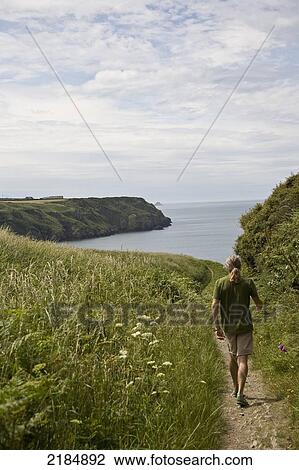 United Kingdom, Wales, Rear View Of Man Walking On Coastal Path; Pembrokeshire View Large Photo Image Stock Image - United Kingdom, Wales, Rear View Of Man Walking On Coastal Path; Pembrokeshire. Fotosearch