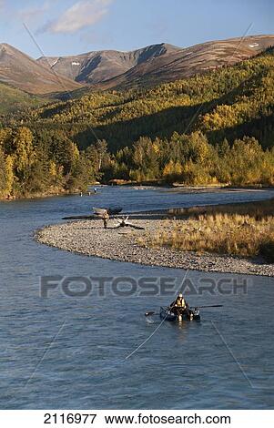 Stock Photo - United States, Alaska, Kenai River, fishermen, pontoon boat in foreground.. Fotosearch