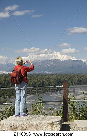 Stock Photograph - USA, Alaska, a woman at a viewpoint of Mt McKinley at mile 135 of Parks Highway.. Fotosearch