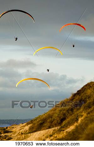 Stock Image - USA, California, Paragliders Flying Over Coast; La Jolla. Fotosearch