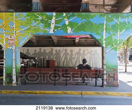Stock Photo - USA, Colorado, Back view of resting skateboarder; Glenwood Springs. Fotosearch
