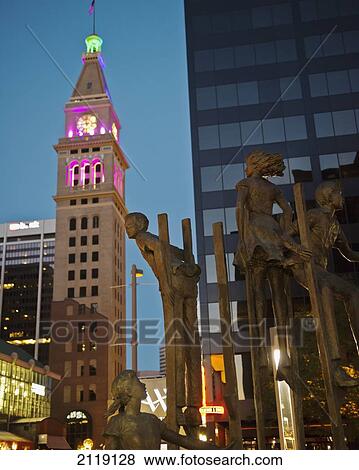 Stock Photo - USA, Colorado, Bronze sculpture of children playing on stilts situated on 16th Street mall at night; Denver. Fotosearch