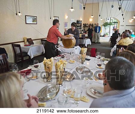 Stock Image - USA, Colorado, II Bisto; Grand Junction, Cutting block of parmesan cheese in Italian restaurant. Fotosearch