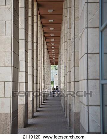 Stock Image - USA, Colorado, Middle aged couple walking near Denver Art Museum; Denver. Fotosearch