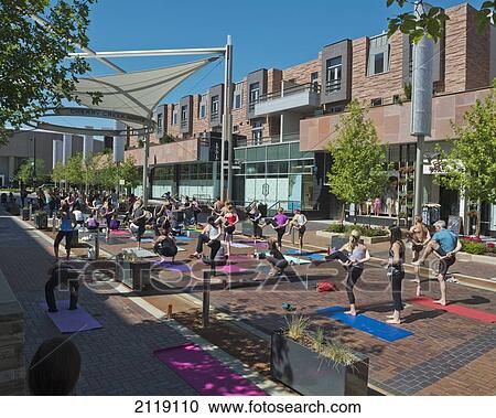 Stock Image - USA, Colorado, Outdoor yoga class on pedestrians street at Cherry Creek North; Denver. Fotosearch