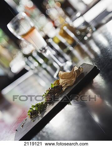 Stock Image - USA, Colorado, quail egg and house made seed tuile at Le Grand Bistro; Denver, fresh herbs, cornichons, purple onions, Steak tartare. Fotosearch