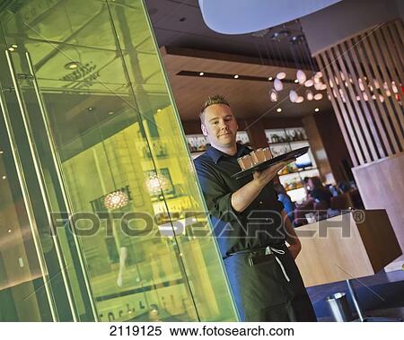 Stock Photography - USA, Colorado, Waiter at Corner Office restaurant and Martini Bar; Denver. Fotosearch