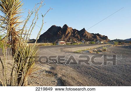 Stock Photo - USA, Dirt road with mountain in background; Texas. Fotosearch
