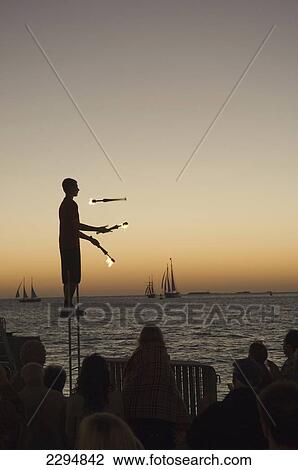 USA, Florida Keys, Juggler using lighted torches entertains crowd who have come to watch sunset at Mallory Square; Key West View Large Photo Image Stock Image - USA, Florida Keys, Juggler using lighted torches entertains crowd who have come to watch sunset at Mallory Square; Key West. Fotosearch