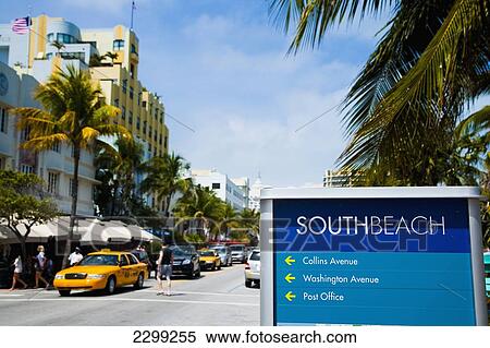 Stock Photography - USA., Florida, Miami, Ocean Drive; South Beach, Bright yellow taxi passing South Beach sign. Fotosearch