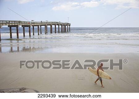 Stock Photo - Usa, Florida, Surfer On Empty Beach; St Augustine. Fotosearch