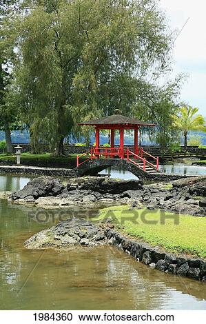 Stock Image - USA, Hawaii Islands, Big Island, Hilo, Red pagoda bridge over water; Liliuokalani Gardens. Fotosearch