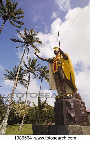 Picture - USA, Hawaii Islands, Big Island, North Kohala, Palm trees and cloudy sky; Kapa'au, Original king Kamehameha I statue. Fotosearch
