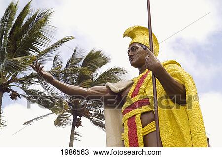 Stock Image - USA, Hawaii Islands, Big Island, North Kohala, Palm trees and cloudy sky; Kapa'au, Original king Kamehameha I statue. Fotosearch