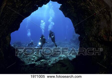 Stock Photography - USA, Hawaii Islands, Divers At Entrance To Lava Tube; Lanai. Fotosearch