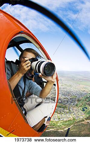 Stock Photo - USA, Hawaii Islands, Female Photographer Shooting From Helicopter; Maui. Fotosearch