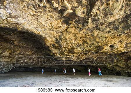 Stock Image - USA, Hawaii Islands, Kauai, People exploring caves; Maniniholo Dry Caves. Fotosearch