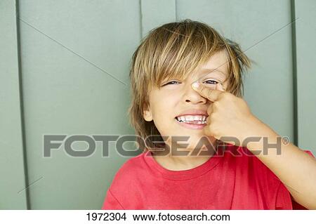 Picture - USA, Hawaii Islands, Kauai, Young Boy Points To His Nose; North Shore. Fotosearch