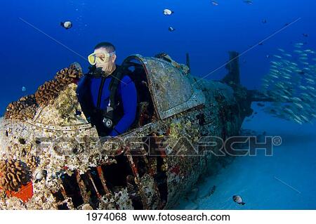 Stock Photo - USA, Hawaii Islands, Male Diver Exploring World War II Corsair Fighter Plane Wreck; Oahu. Fotosearch