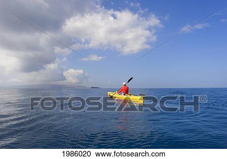 Stock Image - USA, Hawaii Islands, Man in yellow kayak on calm ocean of southern coast; Maui. Fotosearch