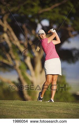 Picture - USA, Hawaii Islands, Maui, Female golfer swinging golf club; Wailea Gold Golf Course. Fotosearch