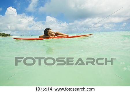 Picture - USA, Hawaii Islands, Oahu, Young Woman Lying On Surfboard In Ocean; Lanikai. Fotosearch