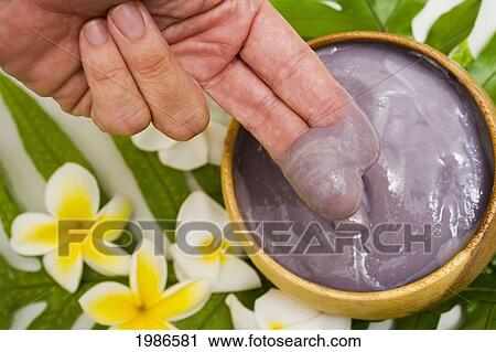 Stock Image - USA, Hawaii Islands, View from above; Kailua, Close-up of fingers scooping Poi out of wooden bowl. Fotosearch