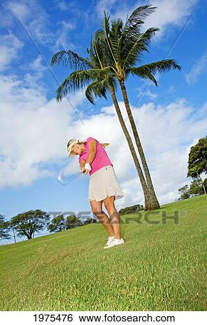 Stock Photograph - USA, Hawaii Islands, Wailea Gold Golf Course; Maui, Female Golfer Swinging Golf Club. Fotosearch