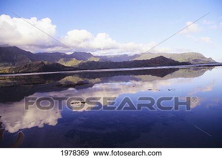 Stock Photo - USA, Hawaii, Kauai, Reflections of mountains in water; Hanalei Bay. Fotosearch