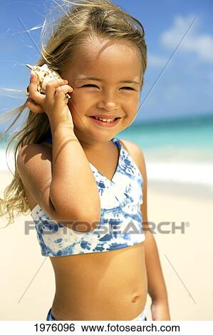 USA, Hawaii, Little Girl Holding Seashell Along Waters Edge; Oahu View Large Photo Image Stock Photograph - USA, Hawaii, Little Girl Holding Seashell Along Waters Edge; Oahu. Fotosearch