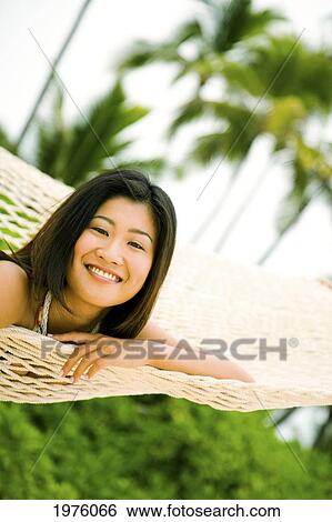 Stock Photograph - USA, Hawaii, Makena, Woman relaxing In Hammock; Lanikai. Fotosearch