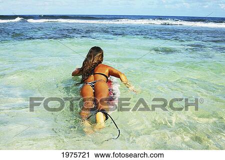 Stock Image - USA, Hawaii, Oahu, Beautiful Surfer Woman In The Ocean; Waikiki. Fotosearch