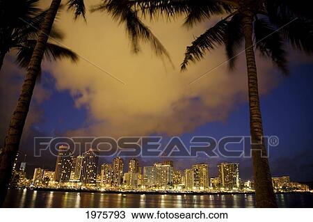 Stock Image - USA, Hawaii, Oahu, Buildings at waterfront seen From Magic Island; Waikiki. Fotosearch