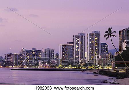 Stock Image - USA, Hawaii, Oahu, Honolulu, Hotels on Waikiki beach at dusk; Waikiki. Fotosearch