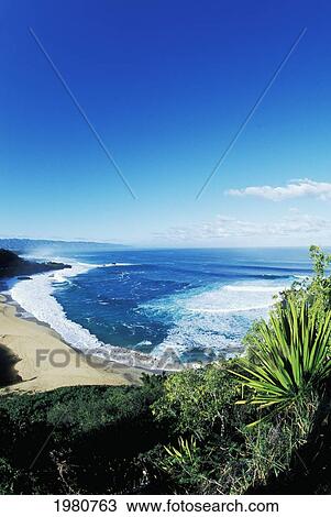 Stock Image - USA, Hawaii, Oahu, Landscape of Waimea Bay from hillside; North Shore. Fotosearch