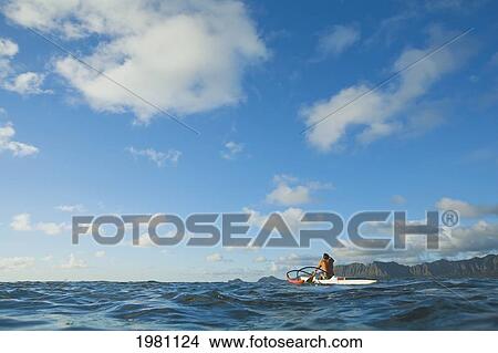 Picture - USA, Hawaii, Oahu, Man paddling outrigger canoe on Pacific ocean; Lanikai. Fotosearch